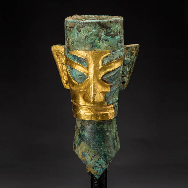 Human head with gold mask